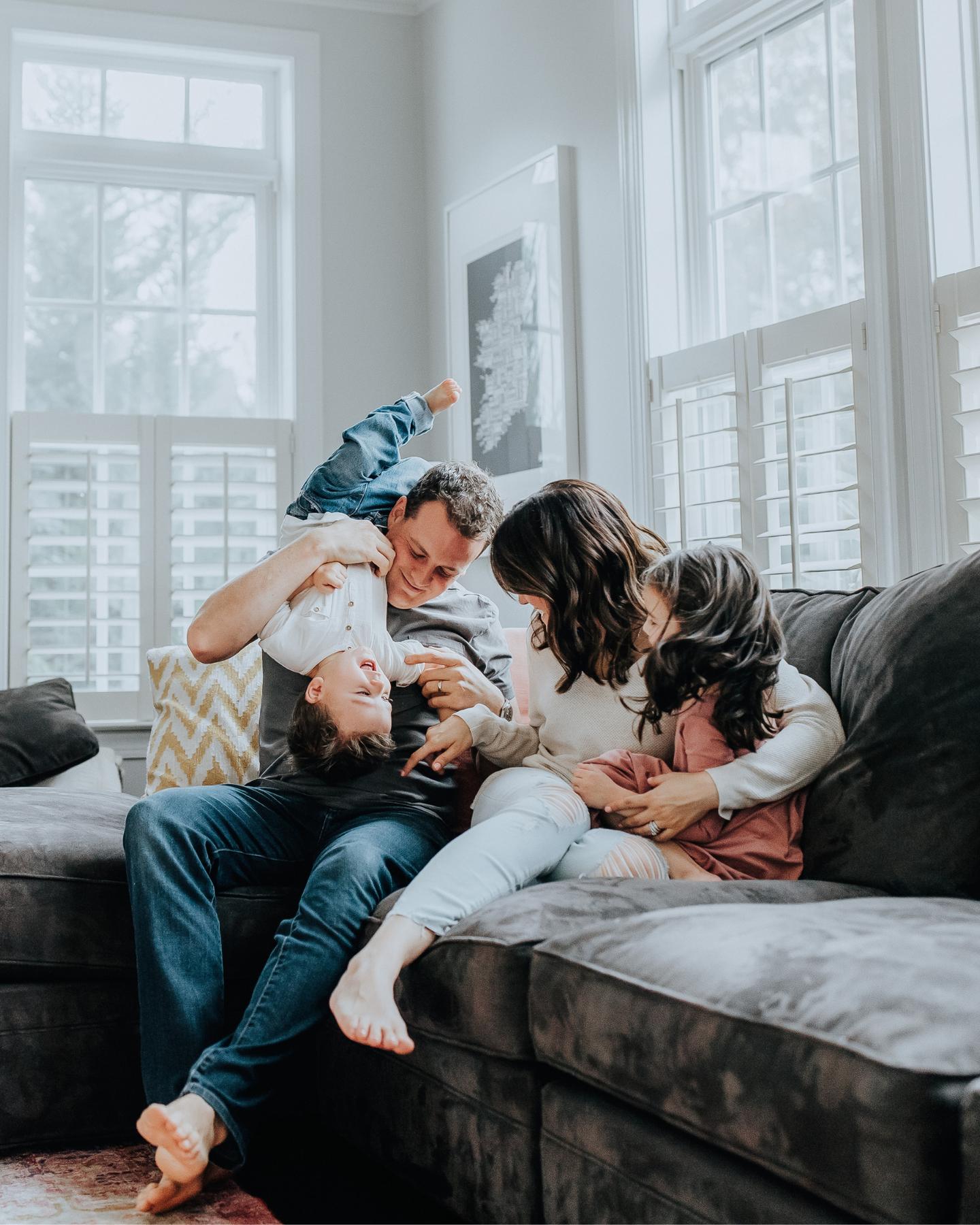 Family laughing together on the sofa in their living room