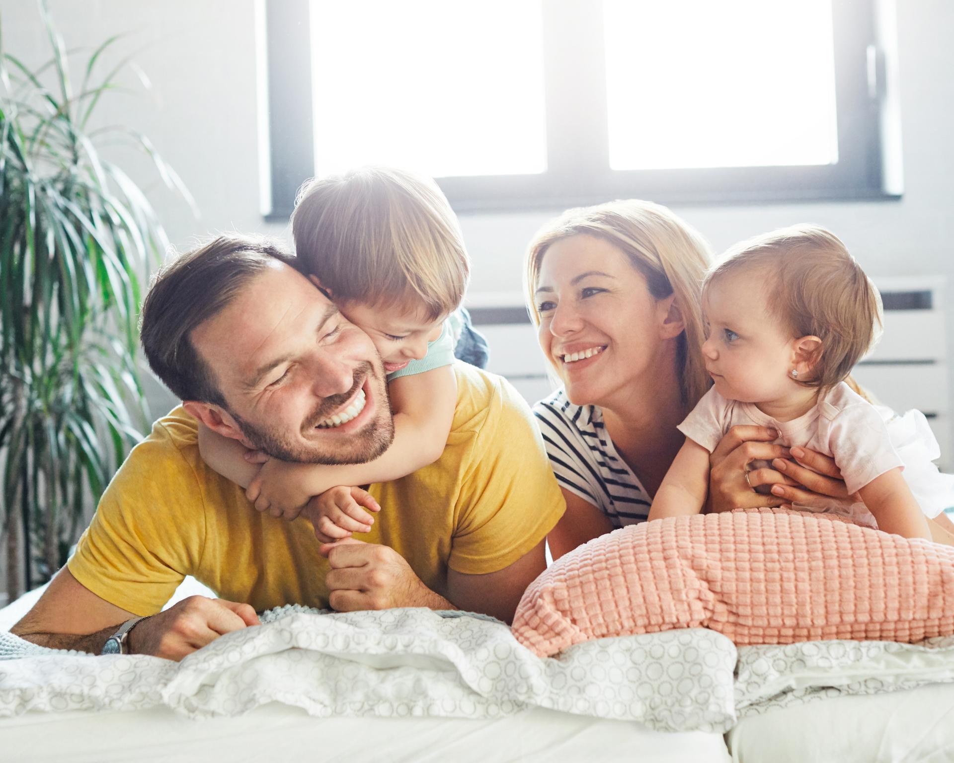 Happy family with two young children relaxing together at home
