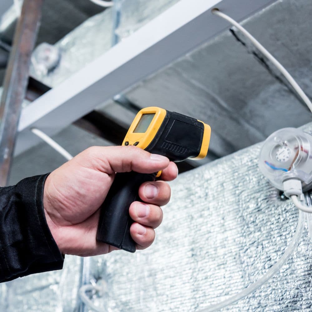 Inspector testing an HVAC duct with a handheld meter